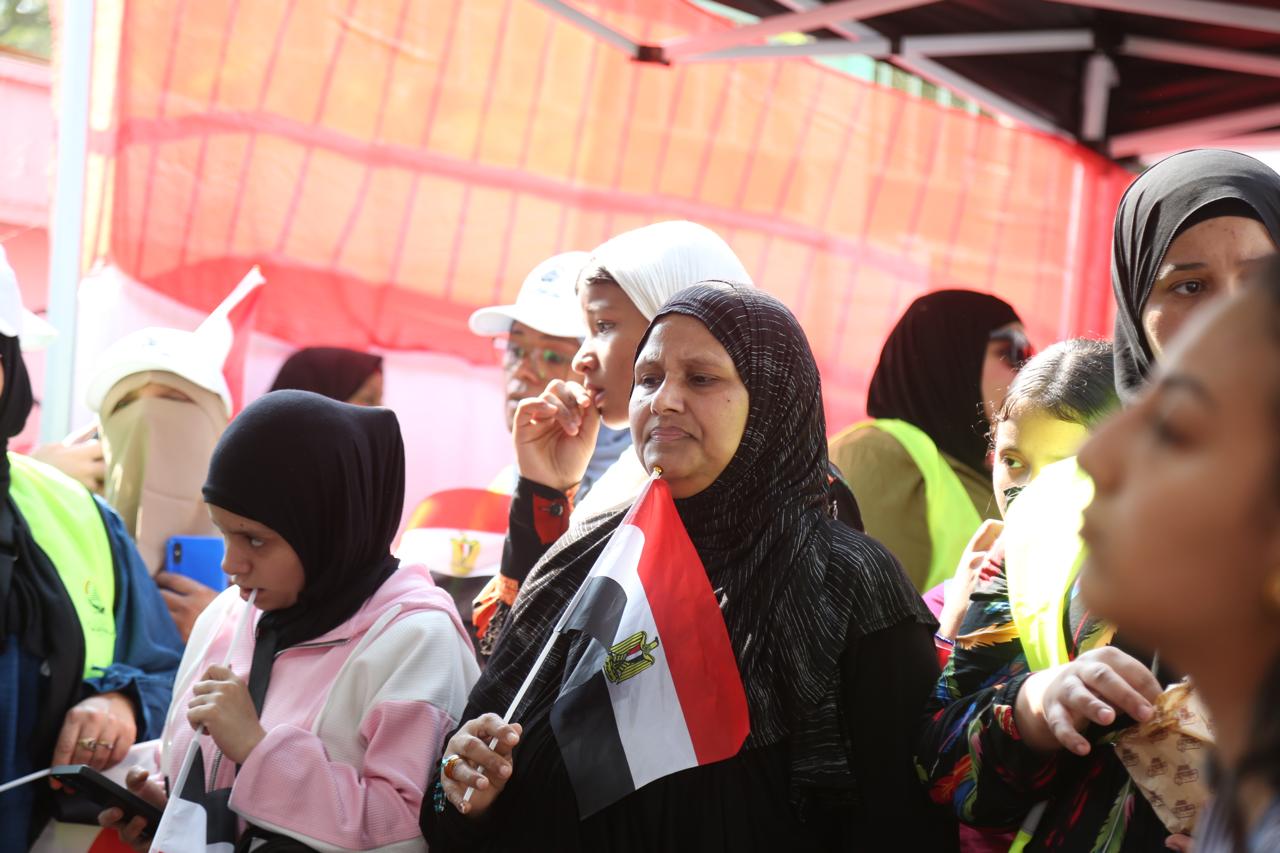 1762783705 379 الناس متجمعة بكثافة في لجنة أم المؤمنين بالعمرانية بالأعلام والأغاني