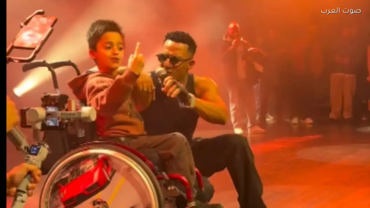 محمد رمضان يتفاعل مع طفل عراقي على كرسي متحرك