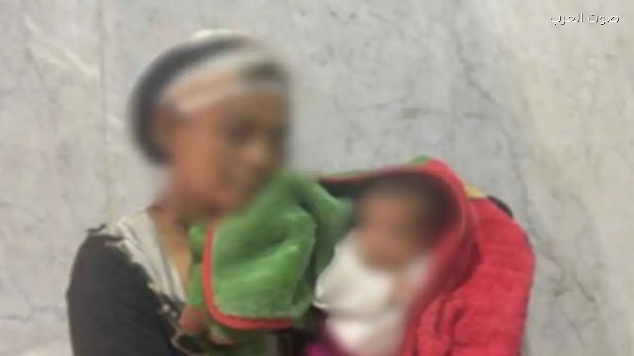 متسولة في الدقي تحمل طفلة رضيعة على الرصيف